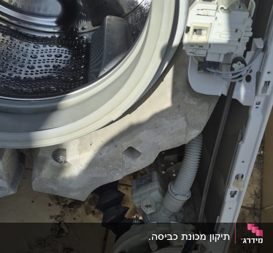 תוף מכונת כביסה פתוח עם חלקים פנימיים חשופים